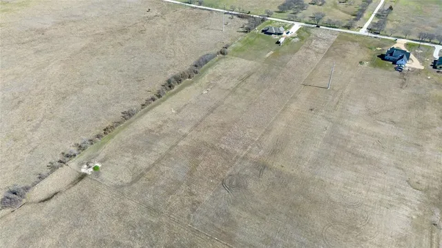 a view of a dry yard with wooden fence
