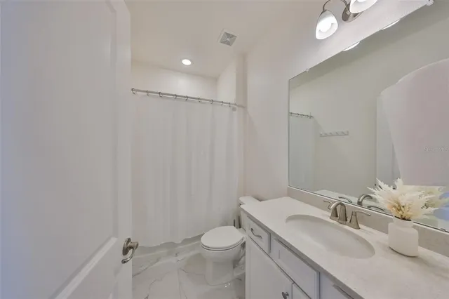 a bathroom with a granite countertop sink toilet and shower