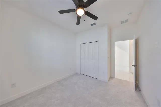 an empty room with a window and a fan