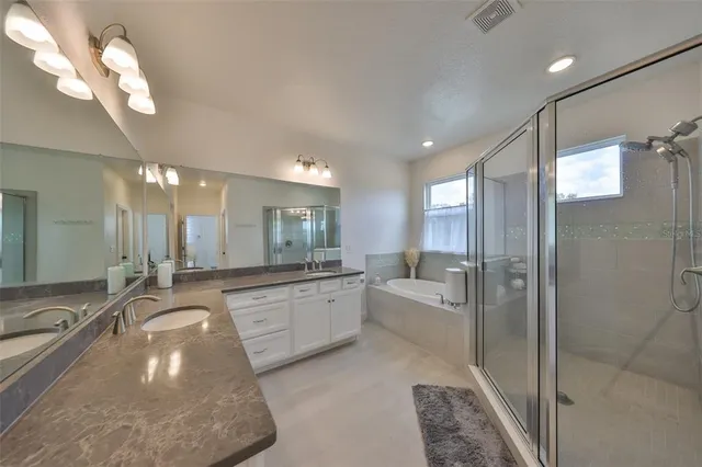a bathroom with a bathtub shower sink mirror and toilet