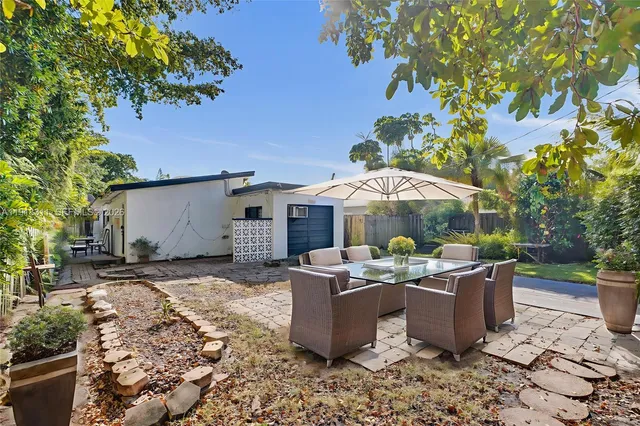 a bedroom with a bed table chair and a potted plant