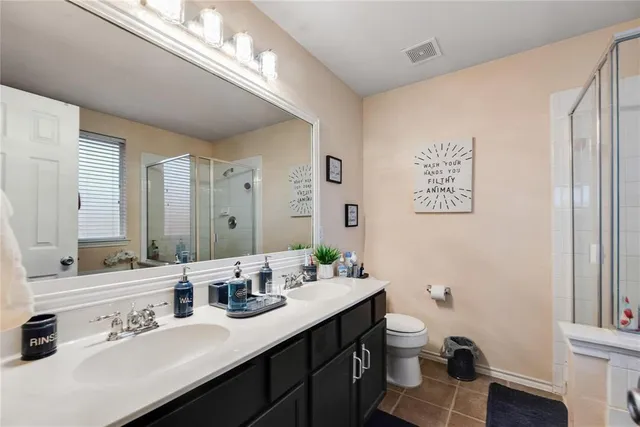 a bathroom with a double vanity sink mirror and toilet