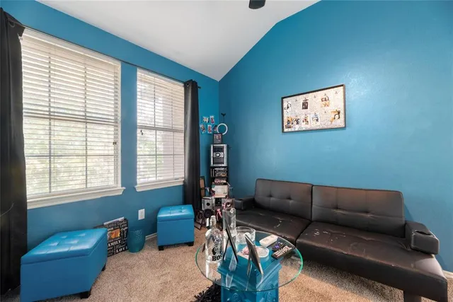 a blue couch sitting in a living room next to a window