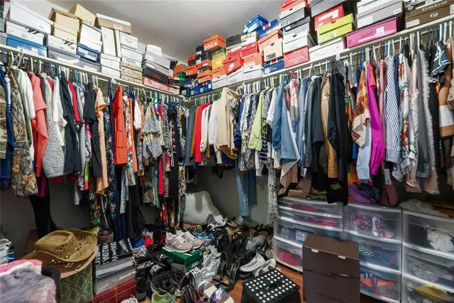 a view of walk in closet with clothes
