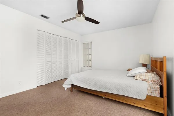 a bedroom with a bed and a ceiling fan