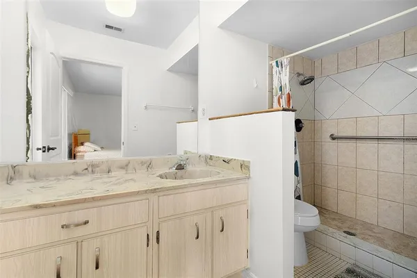 a bathroom with a granite countertop sink toilet and shower
