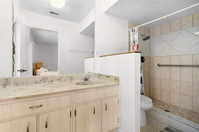 a bathroom with a granite countertop sink toilet and shower