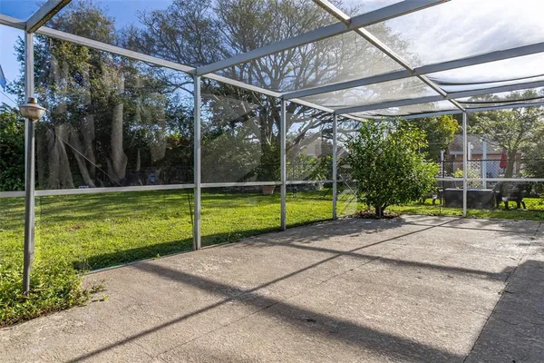 a view of a backyard with floor to ceiling windows and wooden fence