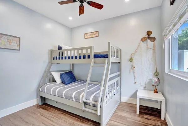 a bedroom with bed and wooden floor