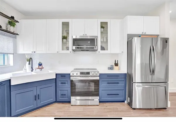 a kitchen with stainless steel appliances granite countertop a refrigerator stove and sink with cabinets