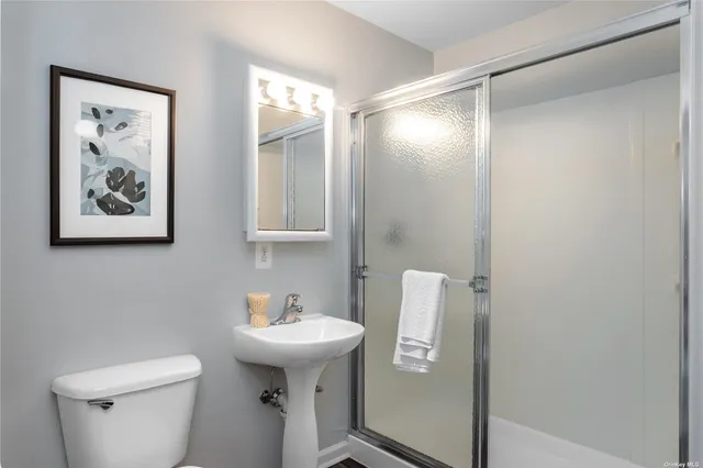 a bathroom with a toilet sink and mirror