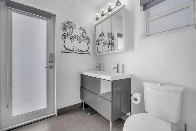 a bathroom with a toilet sink and mirror