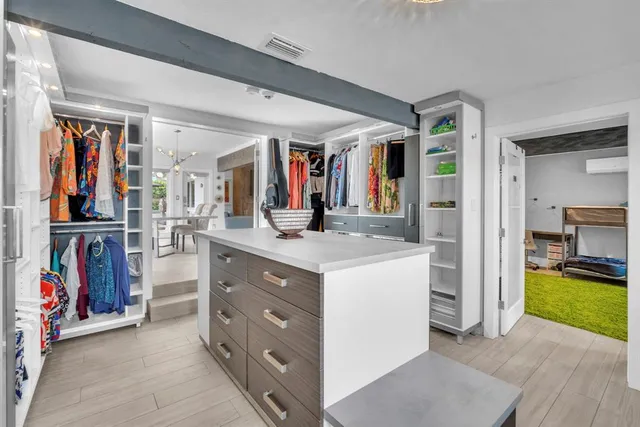 a view of walk in closet with clothes and shoes
