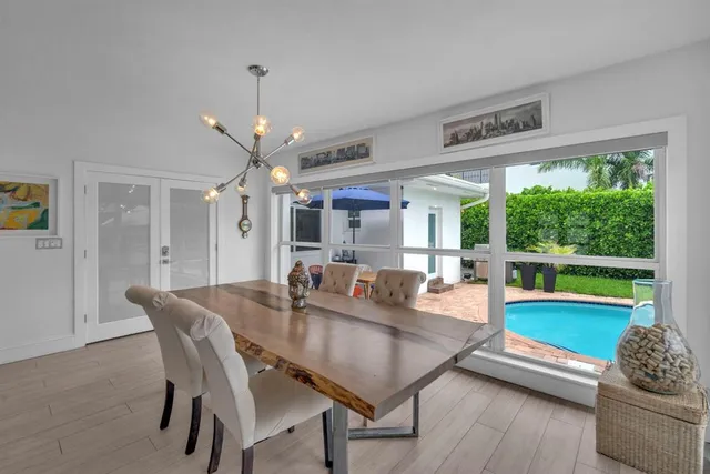 a dining room with furniture a large window and a rug