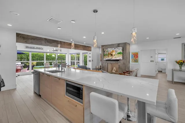 a large kitchen with stainless steel appliances a large counter top a stove and a sink