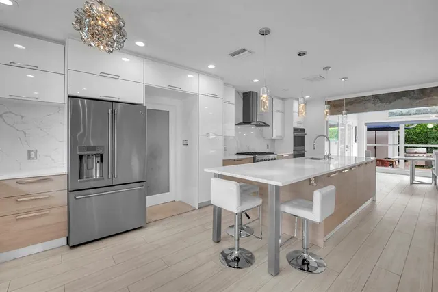 a kitchen with stainless steel appliances kitchen island granite countertop a refrigerator and a stove top oven