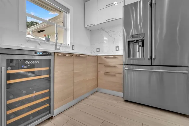 a kitchen with white cabinets and a refrigerator
