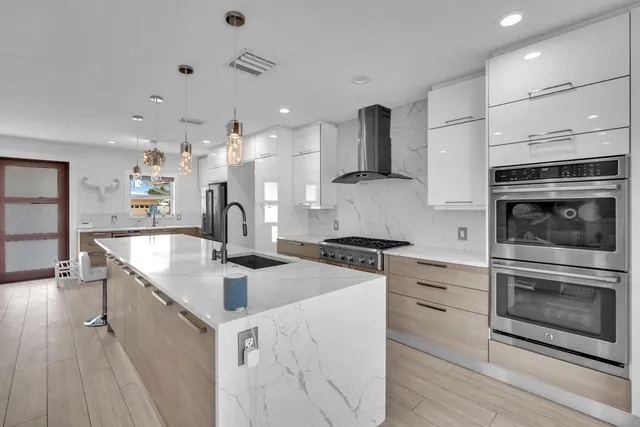 a kitchen with kitchen island a stove a sink and a refrigerator