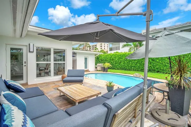 a view of a patio with a table and chairs under an umbrella