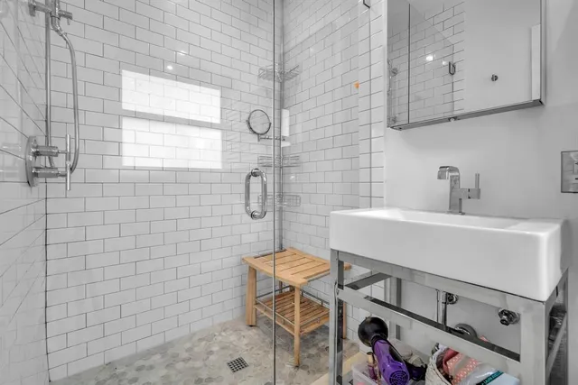 a bathroom with a sink a toilet and shower