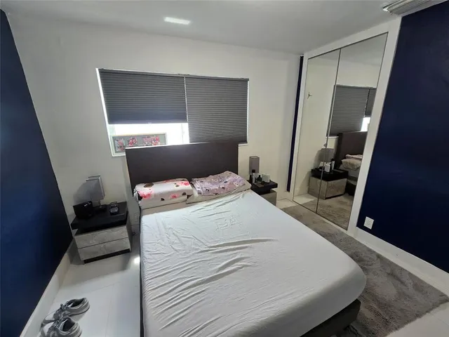 a bedroom with a bed and a large mirror in closet