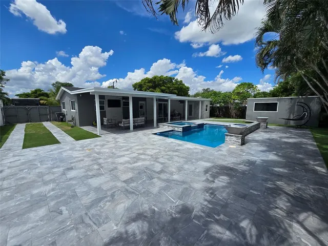 a view of a house with backyard and sitting area