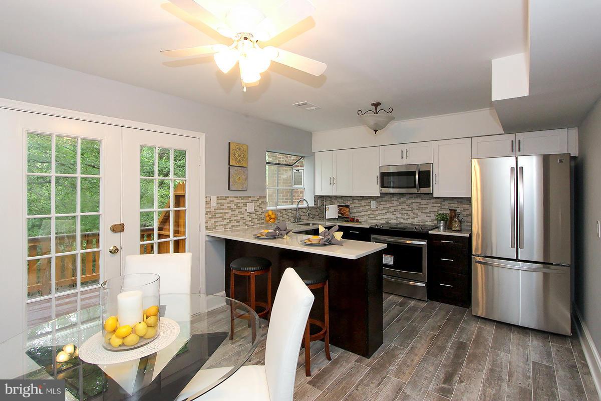2428 South Walter Reed Drive, Unit A Arlington, VA 22206 - Photo 11 of 30 a kitchen with kitchen island granite countertop a stove a sink and a refrigerator