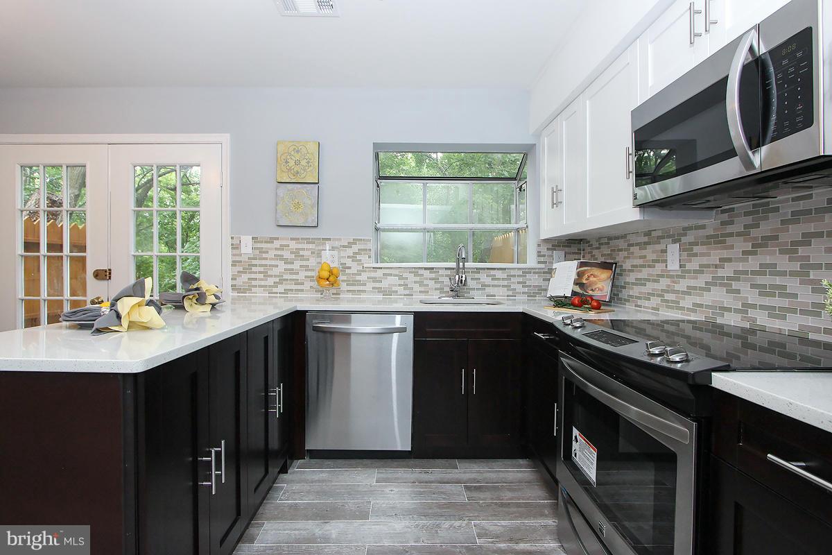 2428 South Walter Reed Drive, Unit A Arlington, VA 22206 - Photo 16 of 30 a kitchen with stainless steel appliances granite countertop a sink stove and microwave