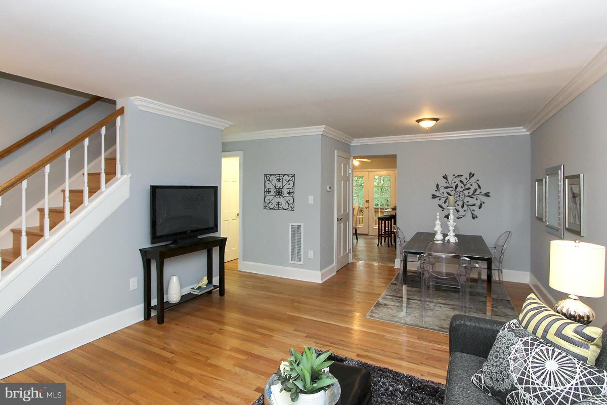 2428 South Walter Reed Drive, Unit A Arlington, VA 22206 - Photo 5 of 30 a living room with furniture a dining table and a flat screen tv