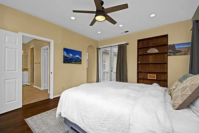 a bedroom with a bed closet and wooden floor