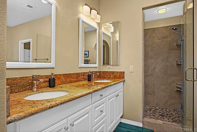 a bathroom with a granite countertop sink mirror and shower