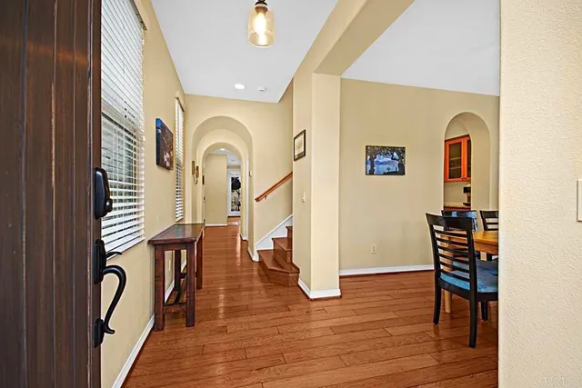 a view of a hallway with wooden floor and furniture