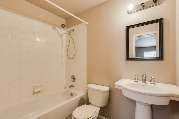 a bathroom with a toilet sink shower and mirror