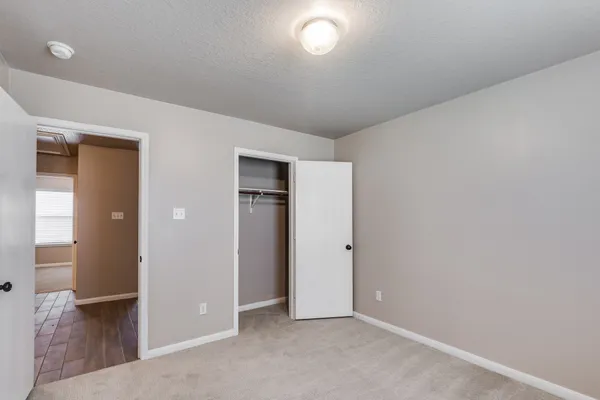 an empty room with mirror and entrance