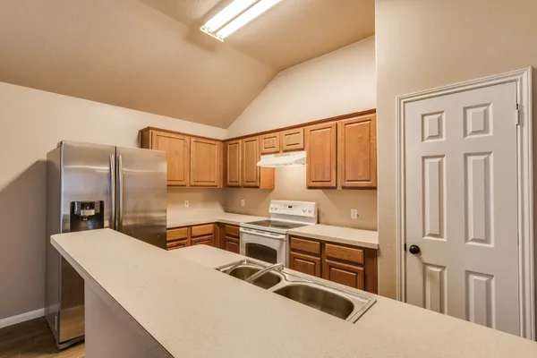 a kitchen with stainless steel appliances a stove a sink and a refrigerator