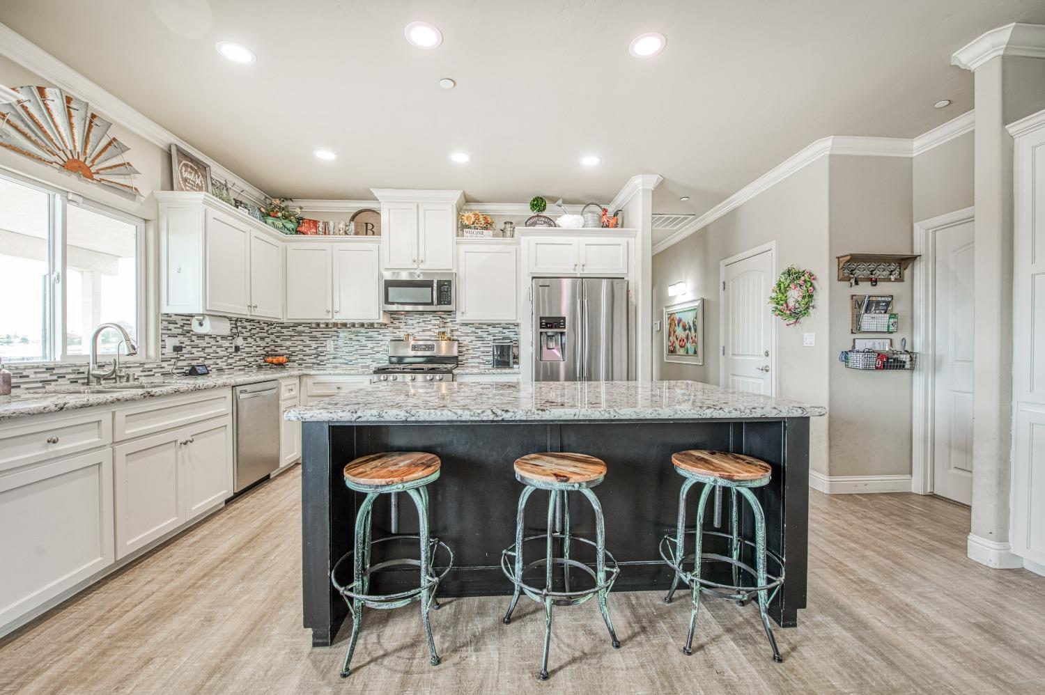 36919 Ave 17 1/2 Madera, CA 93636 - Photo 14 of 77 a kitchen with stainless steel appliances granite countertop a table and chairs in it