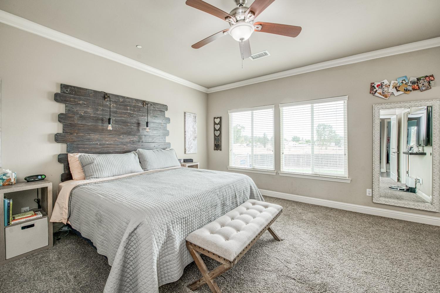 36919 Ave 17 1/2 Madera, CA 93636 - Photo 32 of 77 a spacious bedroom with a bed a window and a chandelier
