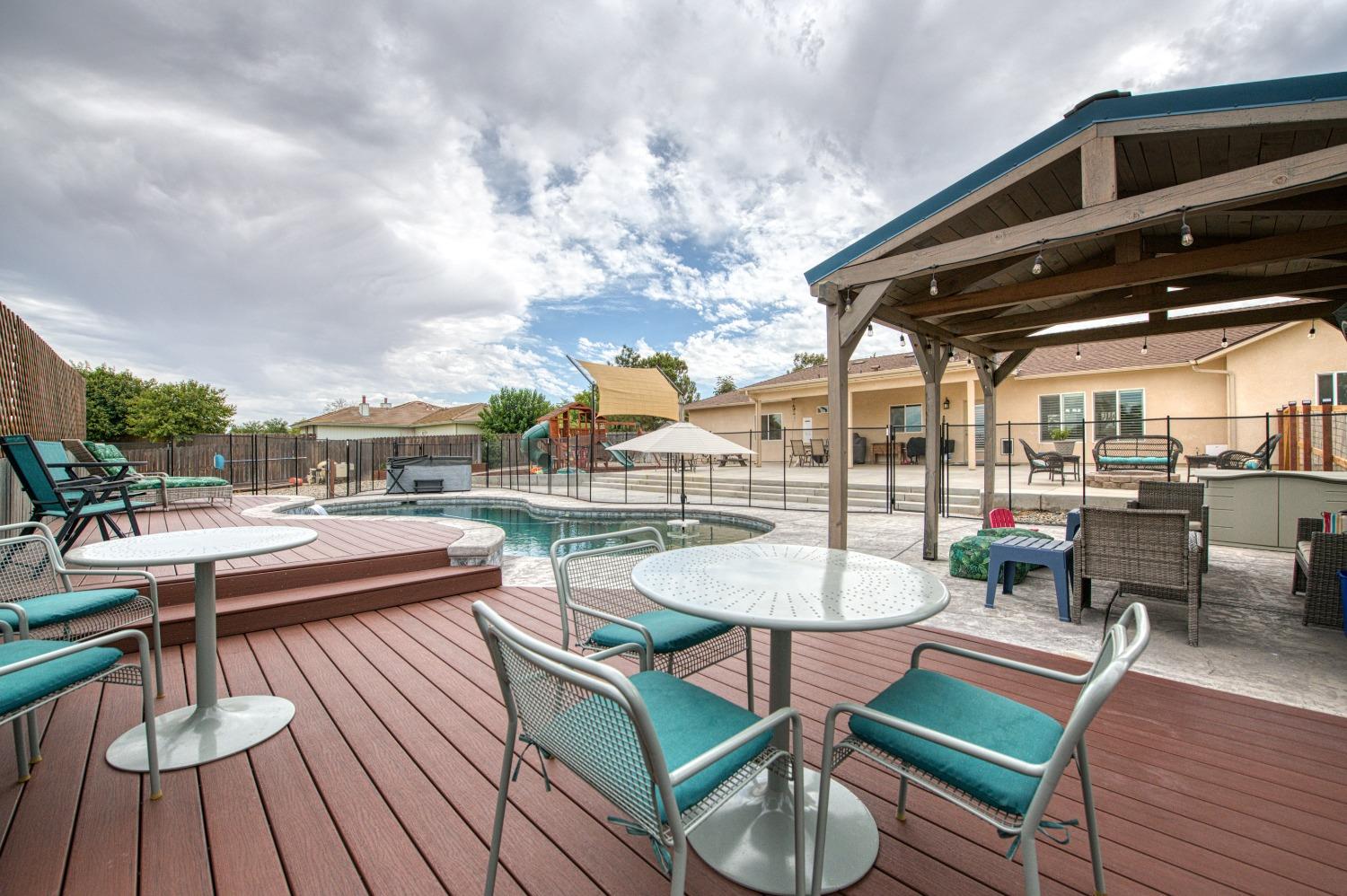 36919 Ave 17 1/2 Madera, CA 93636 - Photo 39 of 77 a view of a patio with a dining table and chairs with wooden floor