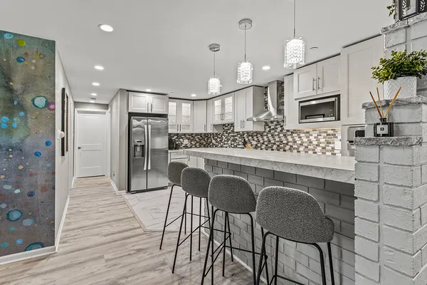 a kitchen with granite countertop white cabinets a sink and white appliances