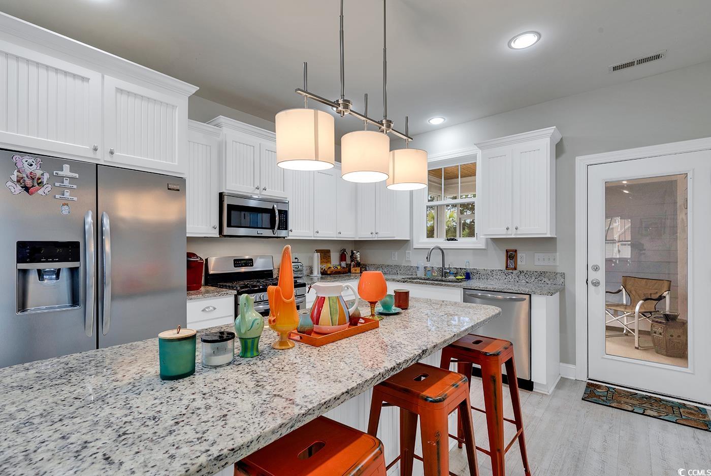500 Percival Court Murrells Inlet, SC 29576 - Photo 10 of 40 Kitchen featuring white cabinets, light hardwood /