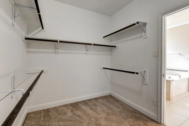 a view of an empty room and chandelier fan