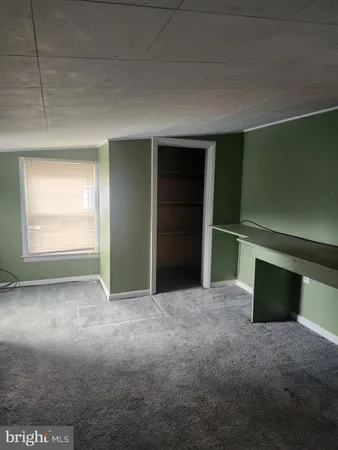 an empty room with closet and windows
