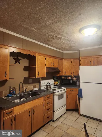 a kitchen with granite countertop a sink stainless steel appliances and cabinets