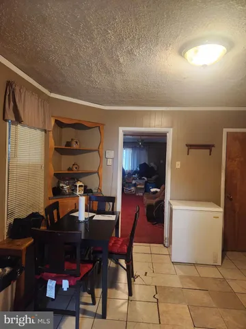 a living room with a couch and a dining table with wooden floor