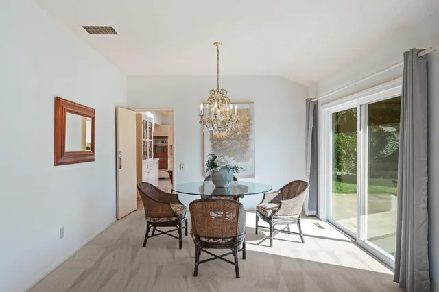 a dining room with furniture a chandelier and wooden floor