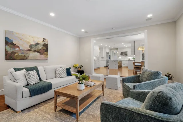 a living room with furniture and a view of kitchen