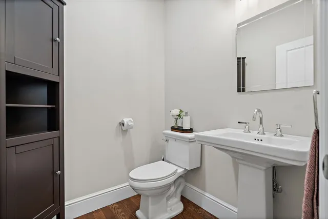 a bathroom with a toilet a sink and mirror