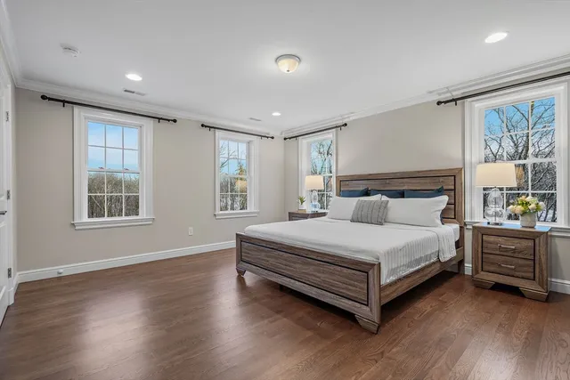 a bed sitting in a spacious bedroom next to a window