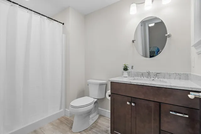a bathroom with a granite countertop sink mirror and toilet