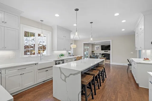 a kitchen with stainless steel appliances kitchen island granite countertop a table chairs sink and cabinets